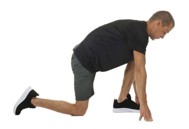 Photo of Runner in starting position on white background