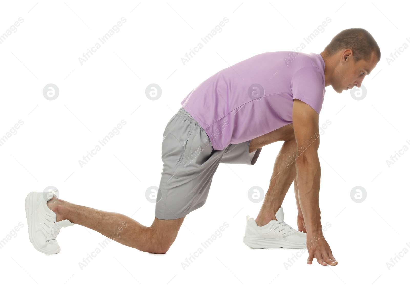 Runner in starting position on white background Photo of Runner in starting position on white background