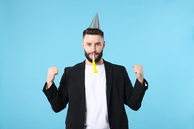 Photo of Happy Birthday. Handsome man with party hat and blower on light blue background