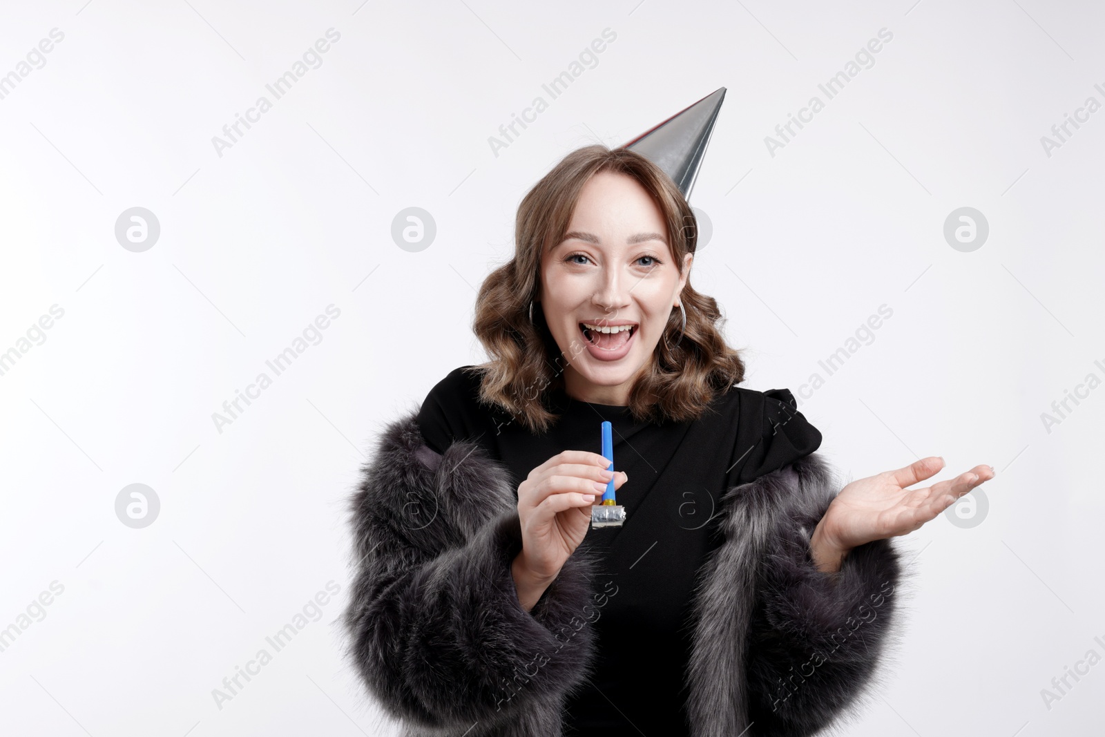 Birthday celebration. Woman with party horn on white background Photo of Birthday celebration. Woman with party horn on white background