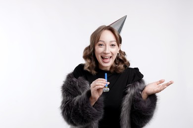 Photo of Birthday celebration. Woman with party horn on white background