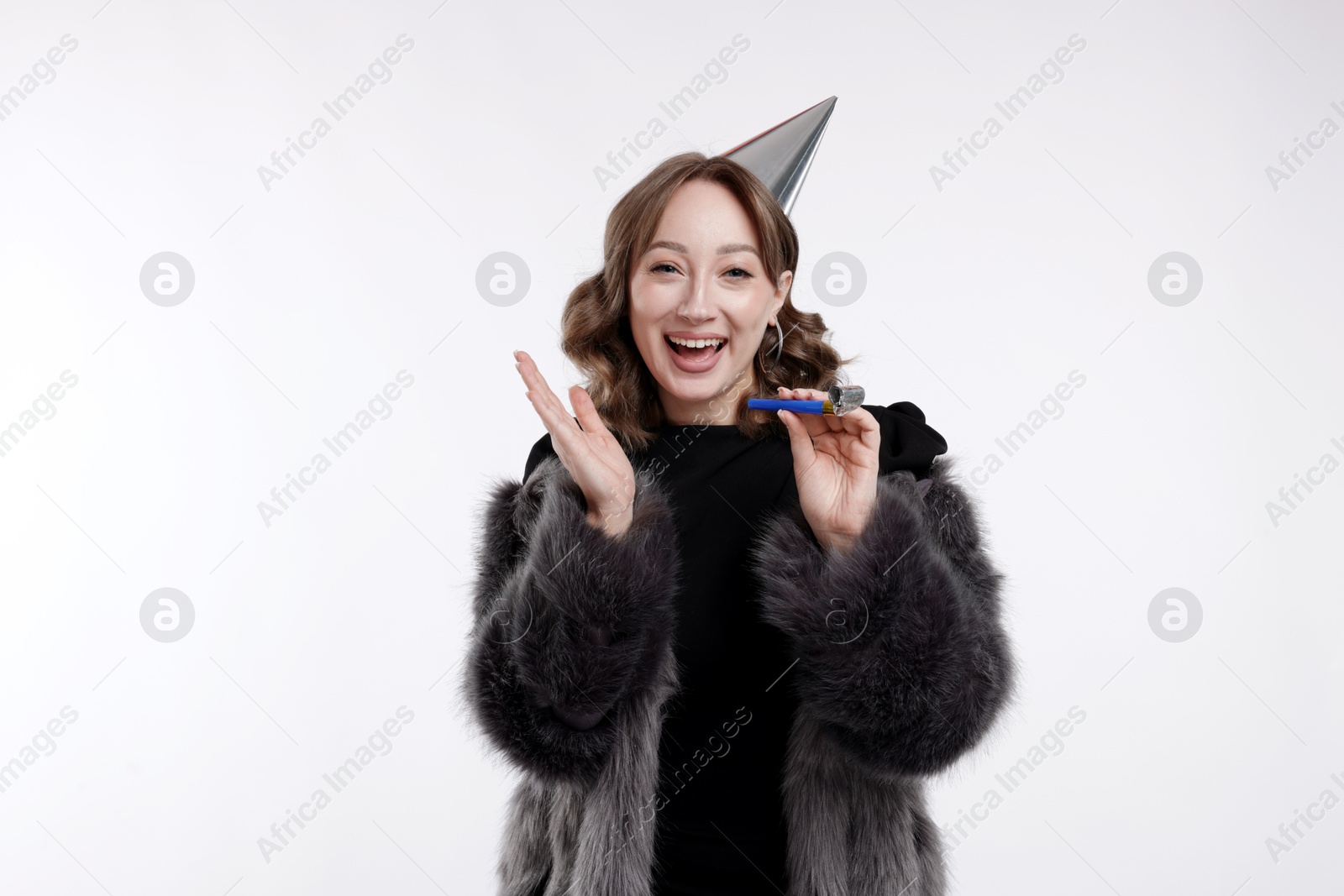Birthday celebration. Woman with party horn on white background Photo of Birthday celebration. Woman with party horn on white background