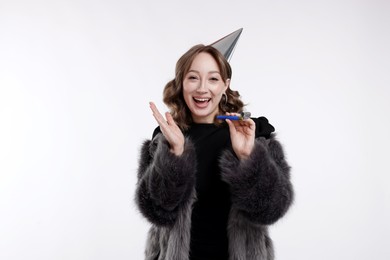 Photo of Birthday celebration. Woman with party horn on white background