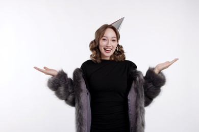 Photo of Birthday celebration. Happy woman with party cone on white background