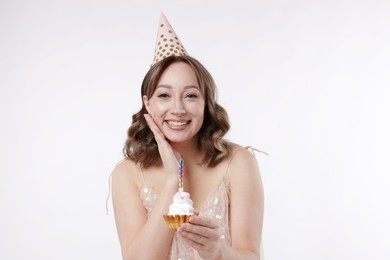 Photo of Birthday celebration. Woman with cupcake on white background