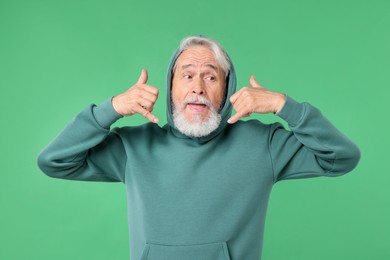 Photo of Elderly man in stylish outfit on green background
