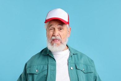 Photo of Elderly man in stylish outfit on light blue background