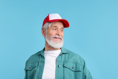 Photo of Elderly man in stylish outfit on light blue background