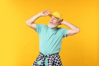 Photo of Elderly man in stylish outfit on orange background