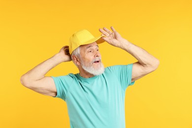 Photo of Elderly man in stylish outfit on orange background