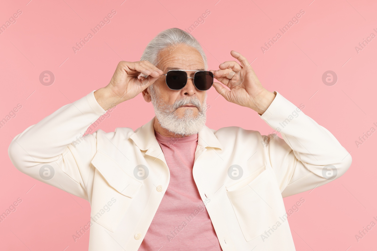 Elderly man in stylish outfit on pink background Photo of Elderly man in stylish outfit on pink background