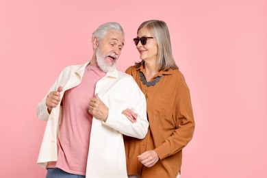 Photo of Senior couple in stylish outfits on pink background