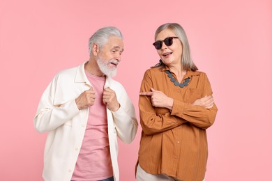Photo of Senior couple in stylish outfits on pink background