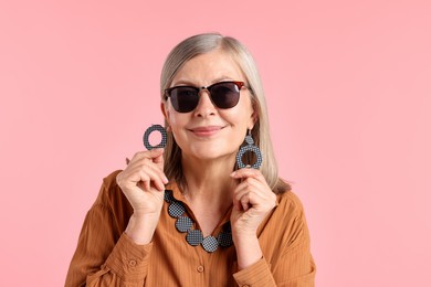 Photo of Senior woman in stylish outfit on pink background