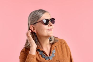 Photo of Senior woman in stylish outfit on pink background