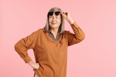 Photo of Senior woman in stylish outfit on pink background