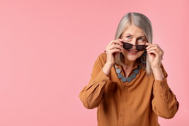 Photo of Senior woman in stylish outfit on pink background, space for text