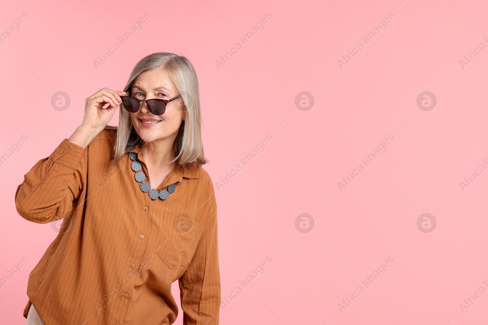 Senior woman in stylish outfit on pink background, space for text Photo of Senior woman in stylish outfit on pink background, space for text