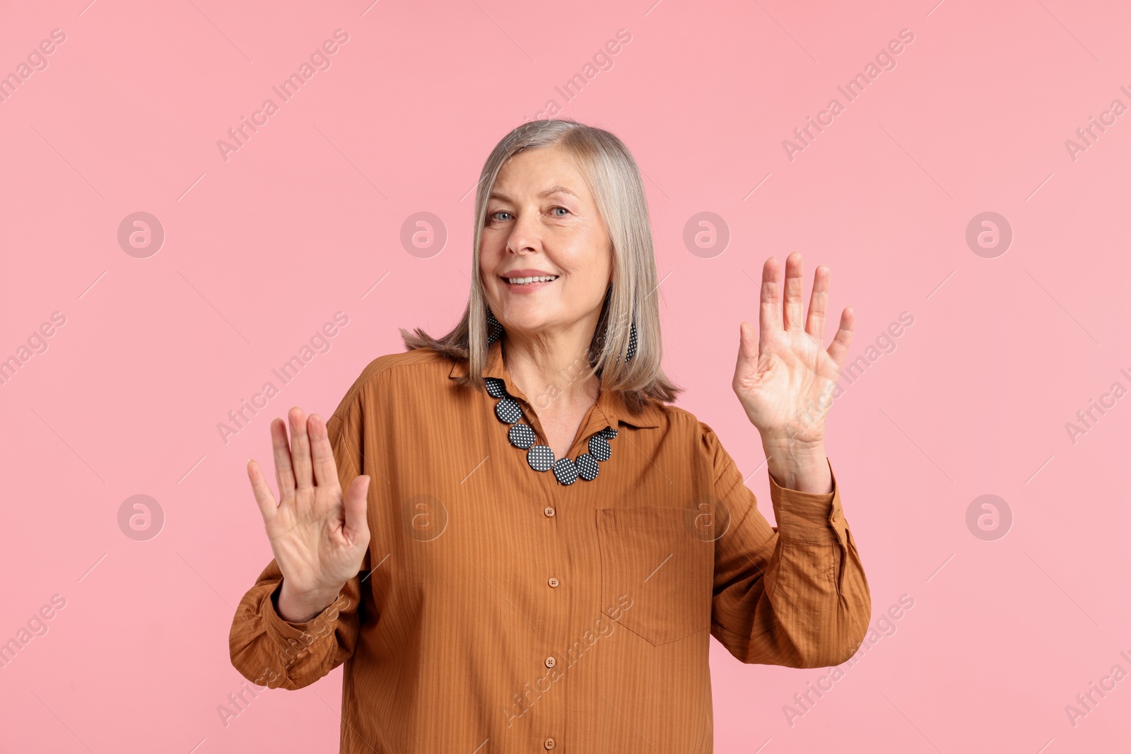 Senior woman in stylish outfit on pink background Photo of Senior woman in stylish outfit on pink background