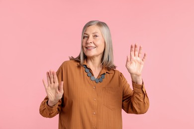 Photo of Senior woman in stylish outfit on pink background
