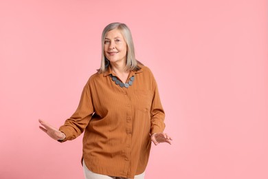 Photo of Senior woman in stylish outfit on pink background, space for text