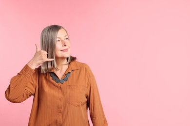 Photo of Senior woman in stylish outfit on pink background, space for text