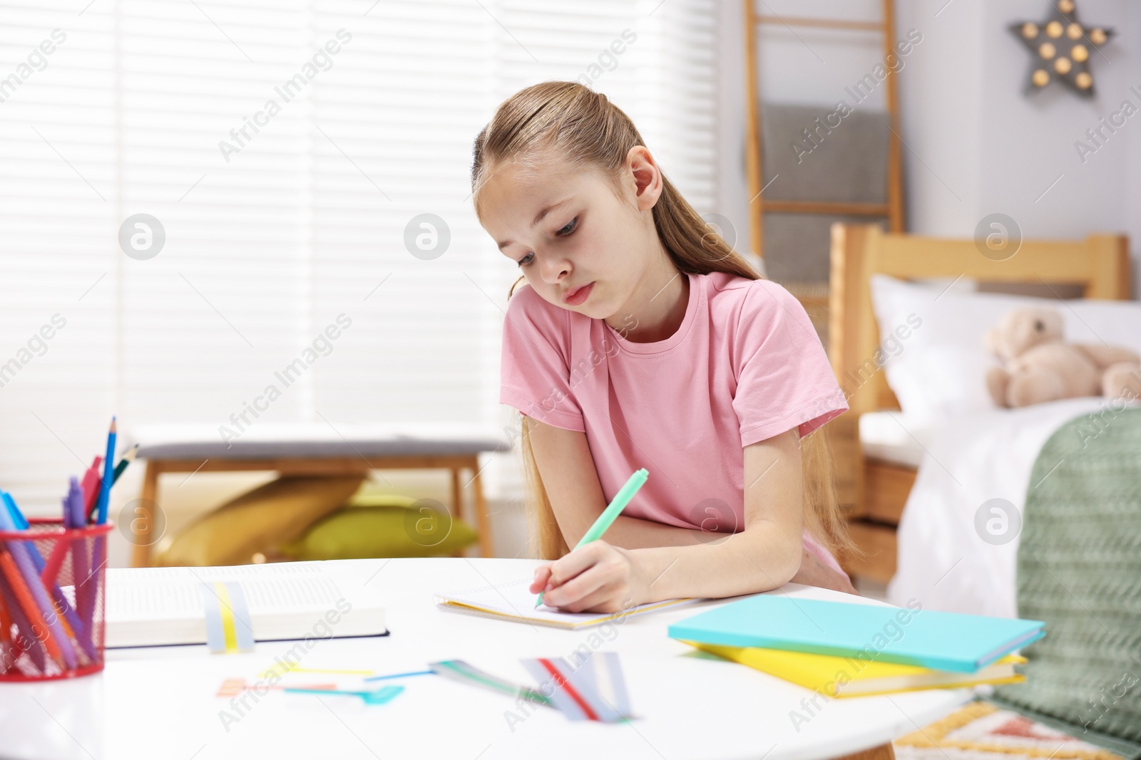 Dyslexia. Little girl writing at table indoors Photo of Dyslexia. Little girl writing at table indoors