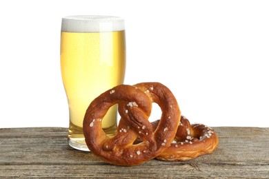 Photo of Tasty pretzels and glass of beer on wooden table against white background
