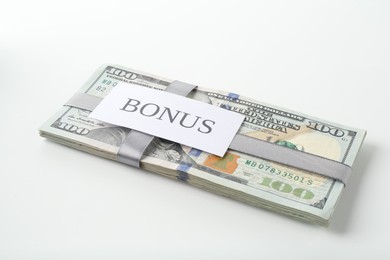 Photo of Dollar banknotes and card with word Bonus isolated on white