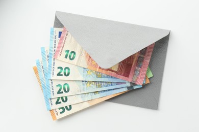 Photo of Money bonus. Envelope with euro banknotes isolated on white, top view