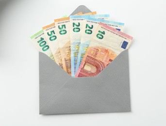 Photo of Money bonus. Envelope with euro banknotes isolated on white, top view