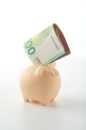 Photo of Money bonus. Piggybank with euro banknotes isolated on white