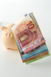 Photo of Money bonus. Piggybank with euro banknotes isolated on white