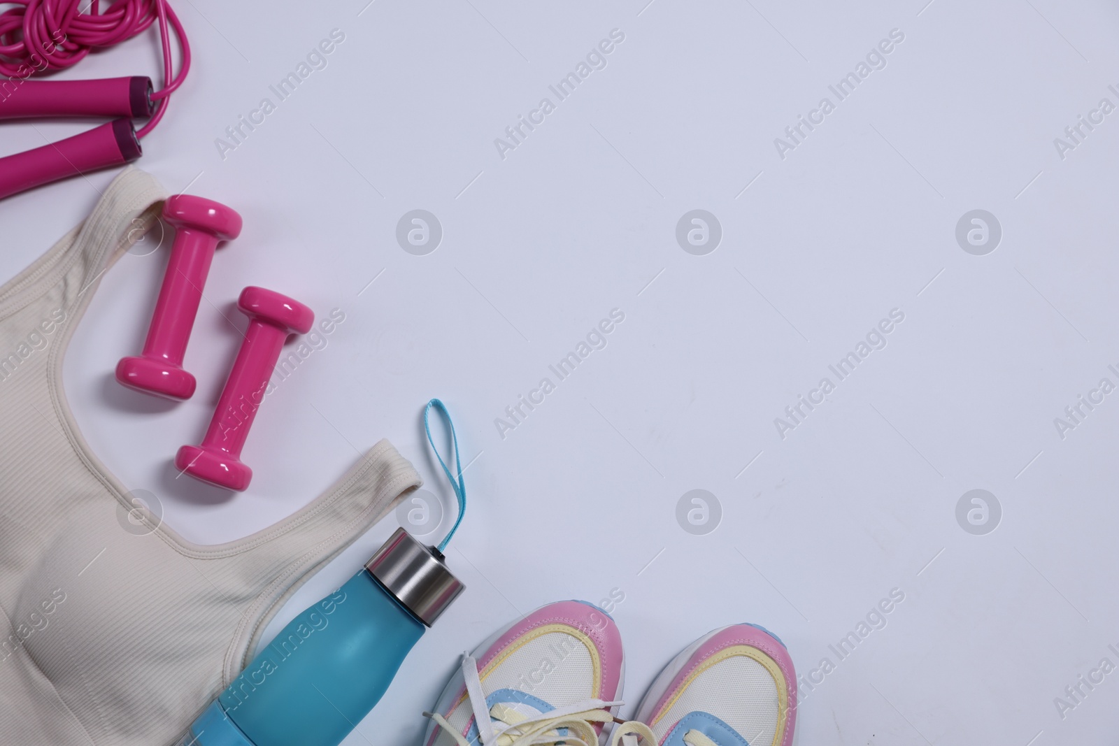 Sportswear, dumbbells, skipping rope and water bottle on white background, flat lay Photo of Sportswear, dumbbells, skipping rope and water bottle on white background, flat lay