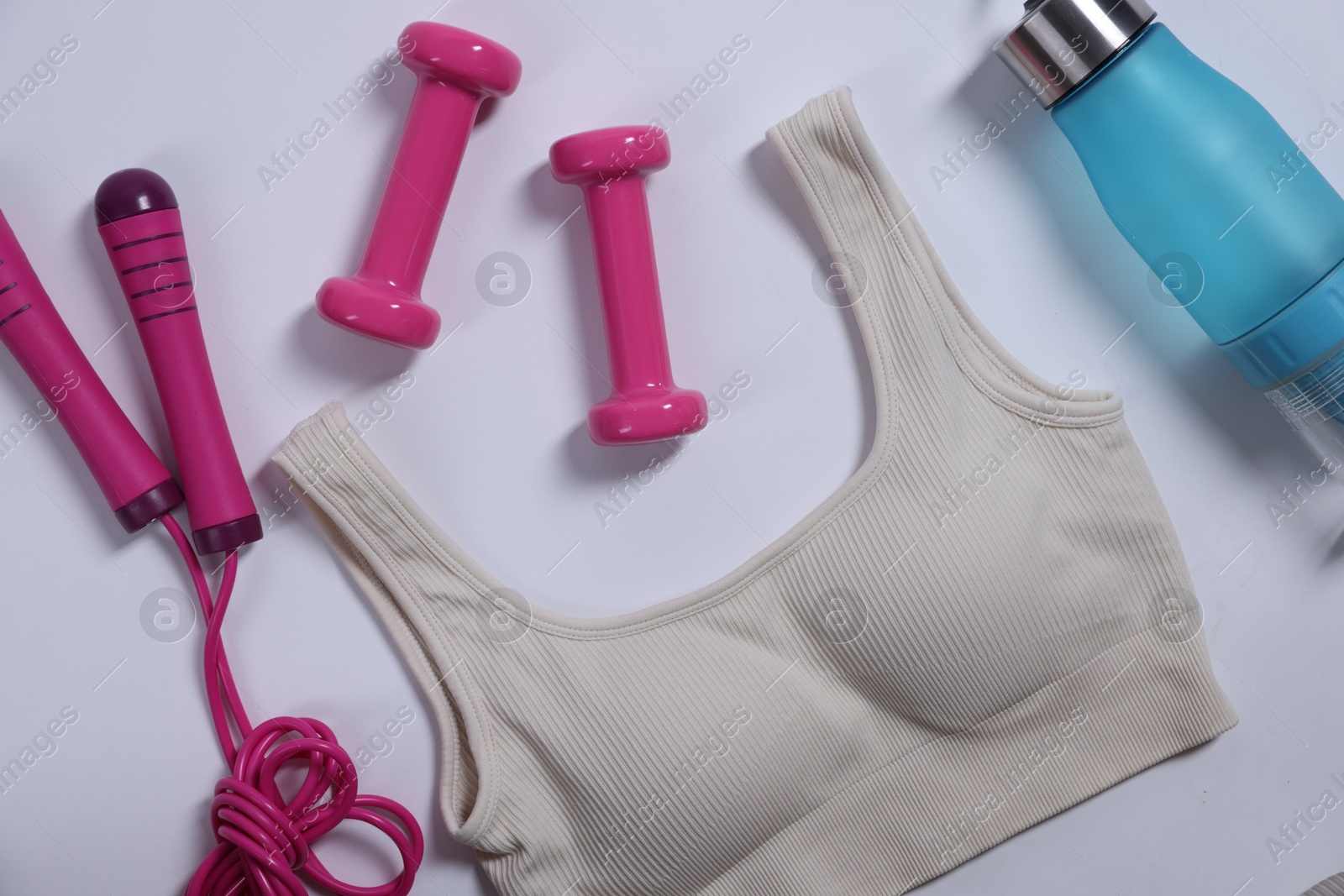 Sportswear, dumbbells, skipping rope and water bottle on white background, flat lay Photo of Sportswear, dumbbells, skipping rope and water bottle on white background, flat lay