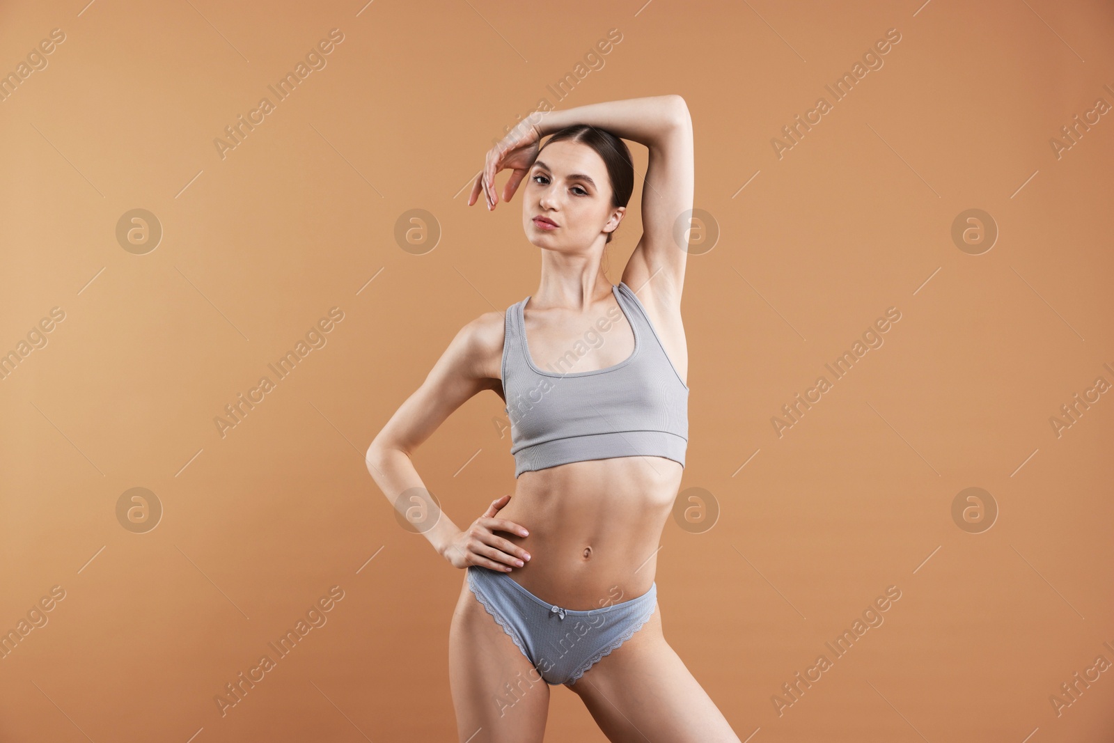 Woman wearing beautiful underwear on dark beige background Photo of Woman wearing beautiful underwear on dark beige background