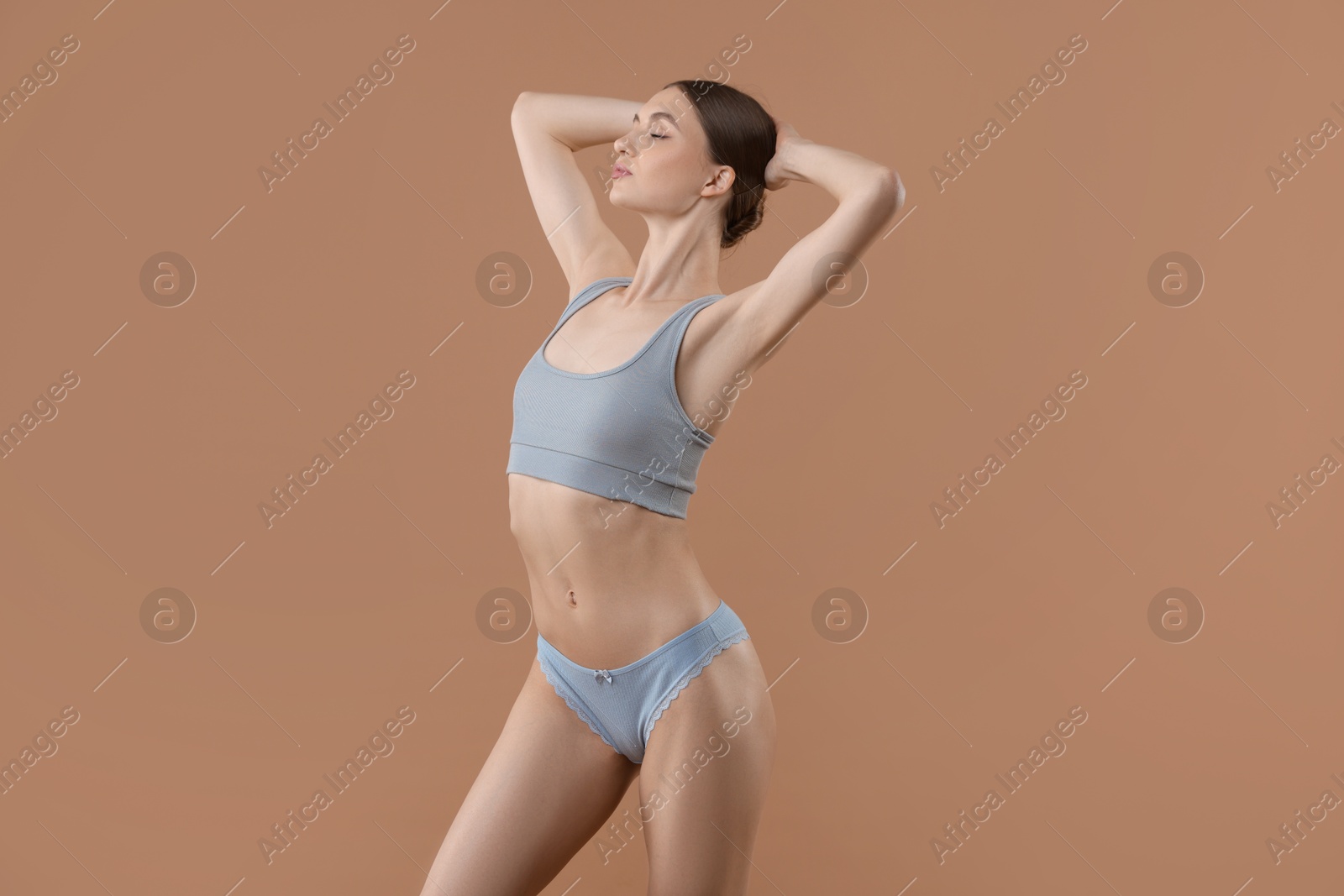 Woman wearing beautiful underwear on dark beige background Photo of Woman wearing beautiful underwear on dark beige background