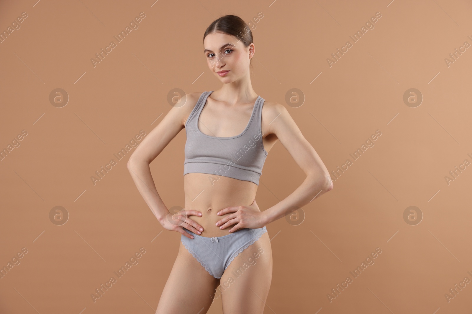 Woman wearing beautiful underwear on dark beige background Photo of Woman wearing beautiful underwear on dark beige background