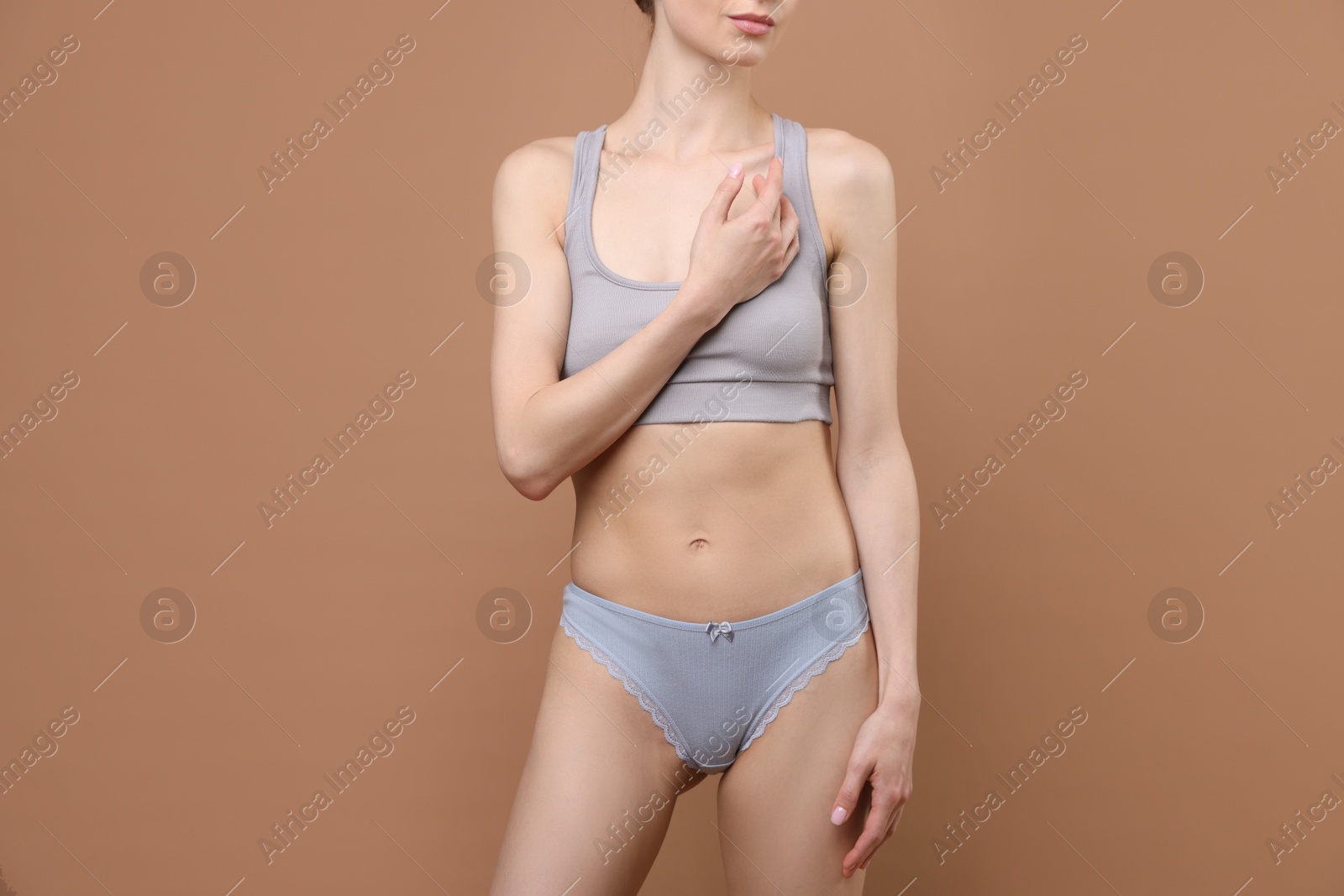 Woman wearing beautiful underwear on brown background, closeup Photo of Woman wearing beautiful underwear on brown background, closeup
