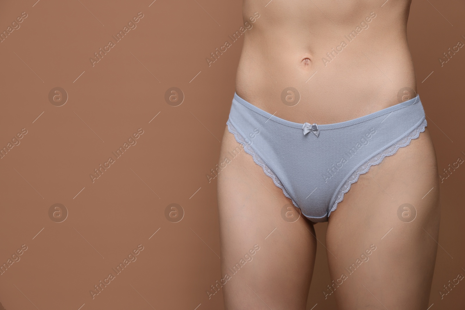 Woman wearing beautiful underwear on brown background, closeup. Space for text Photo of Woman wearing beautiful underwear on brown background, closeup. Space for text