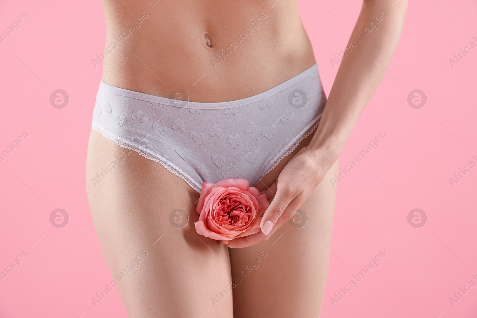 Woman with flower wearing beautiful underwear on pink background, closeup Photo of Woman with flower wearing beautiful underwear on pink background, closeup