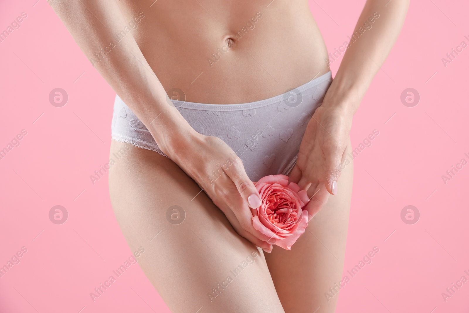 Woman with flower wearing beautiful underwear on pink background, closeup Photo of Woman with flower wearing beautiful underwear on pink background, closeup
