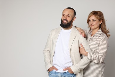 Photo of Portrait of lovely couple on light grey background, space for text