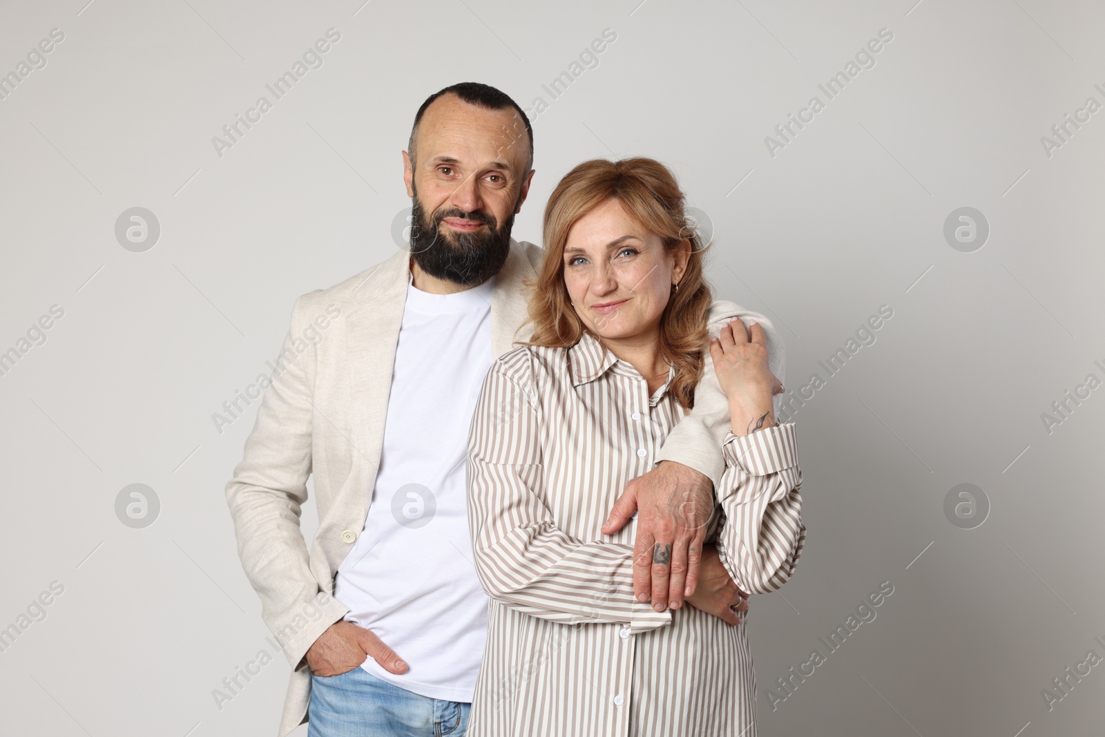 Portrait of lovely couple on light grey background Photo of Portrait of lovely couple on light grey background