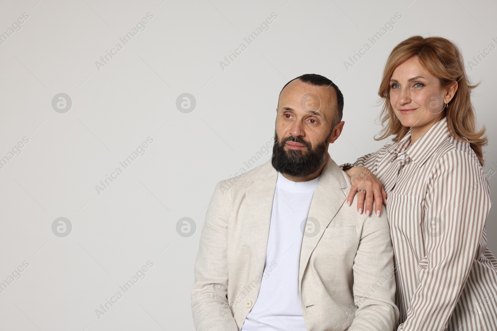 Portrait of lovely couple on light grey background, space for text Photo of Portrait of lovely couple on light grey background, space for text