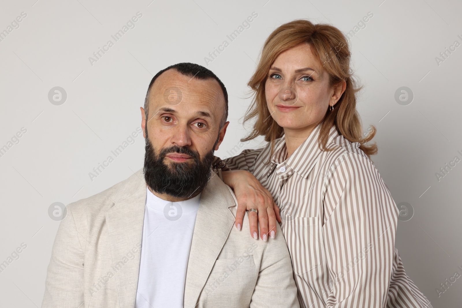 Portrait of lovely couple on light grey background Photo of Portrait of lovely couple on light grey background