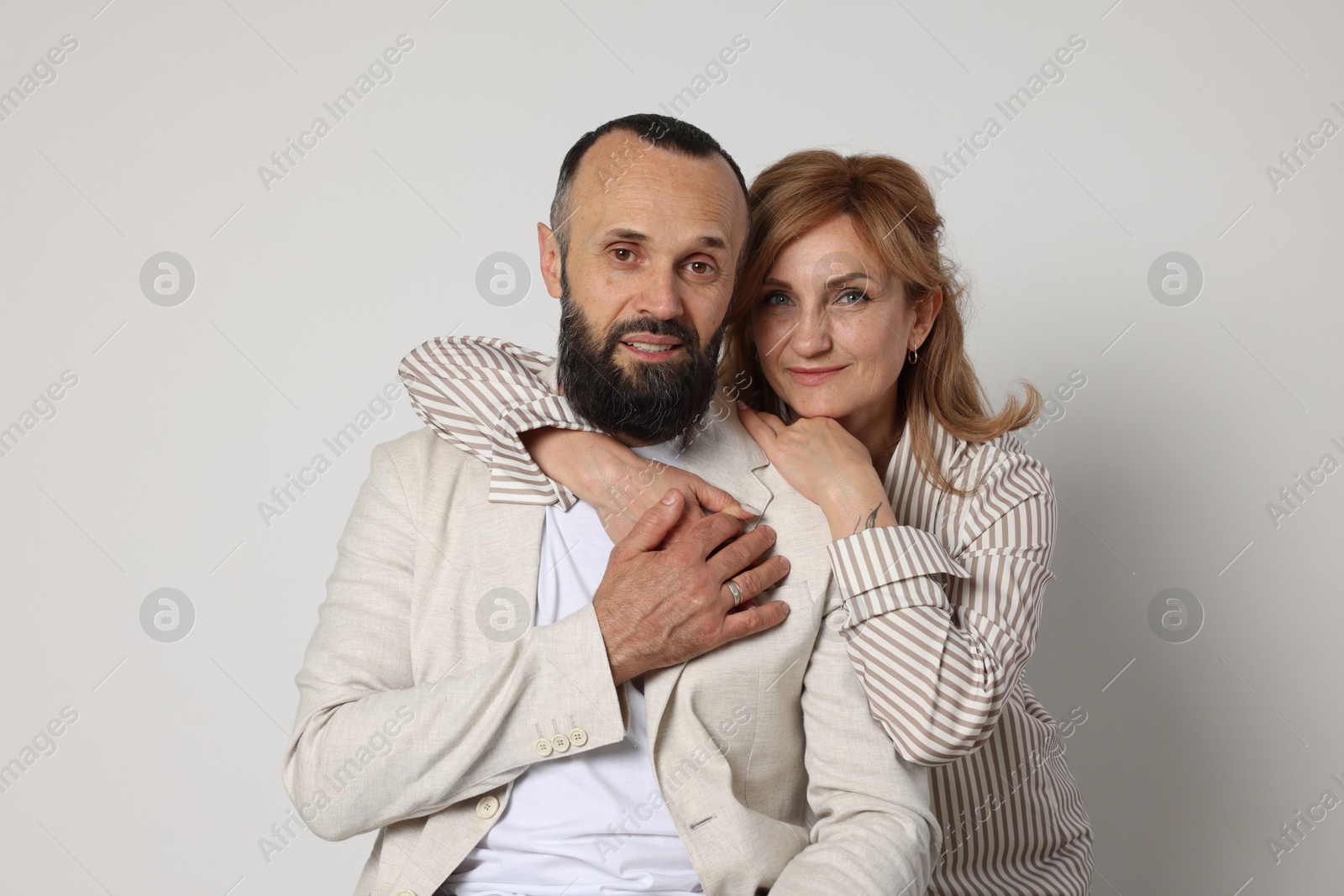 Portrait of lovely couple on light grey background Photo of Portrait of lovely couple on light grey background