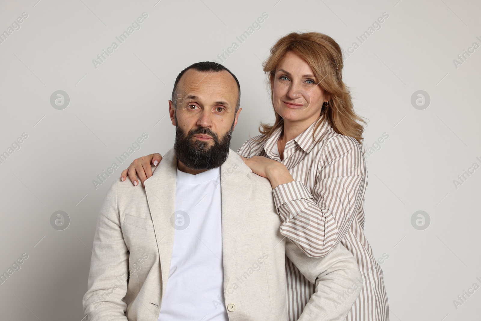 Portrait of lovely couple on light grey background Photo of Portrait of lovely couple on light grey background