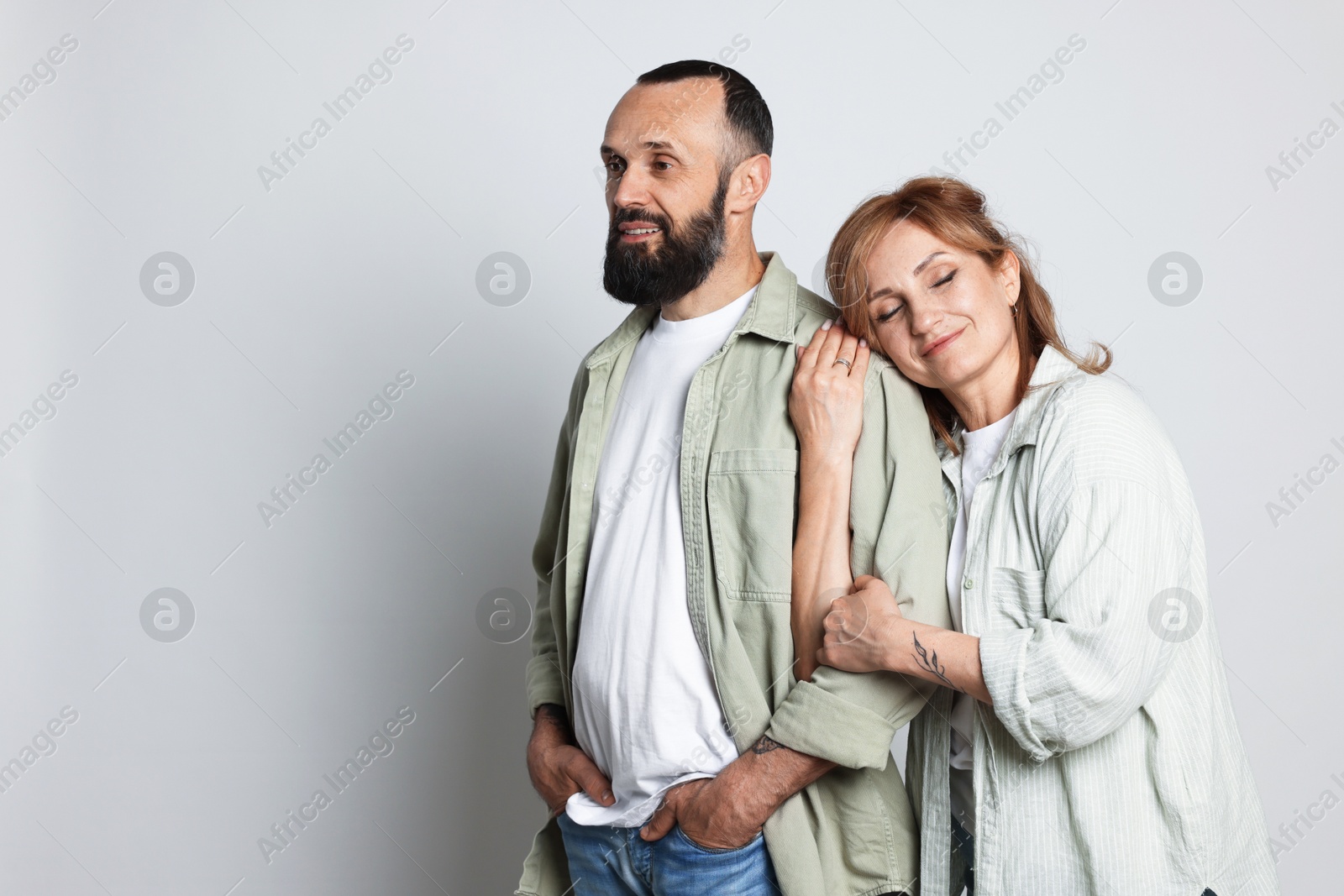 Portrait of lovely couple on light grey background, space for text Photo of Portrait of lovely couple on light grey background, space for text