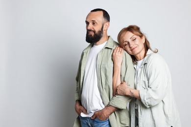 Photo of Portrait of lovely couple on light grey background, space for text